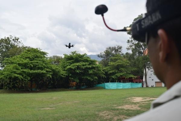 Alex López con las gafas y el dron de fondo