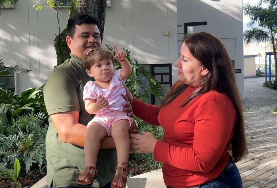 María Victoria cargada por los papás